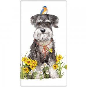 Gray and white Schnauzer dog with blue, orange and white bird on head. Sitting in flowers with collar.