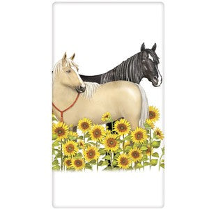 Tan and Black horses standing in field of sunflowers.